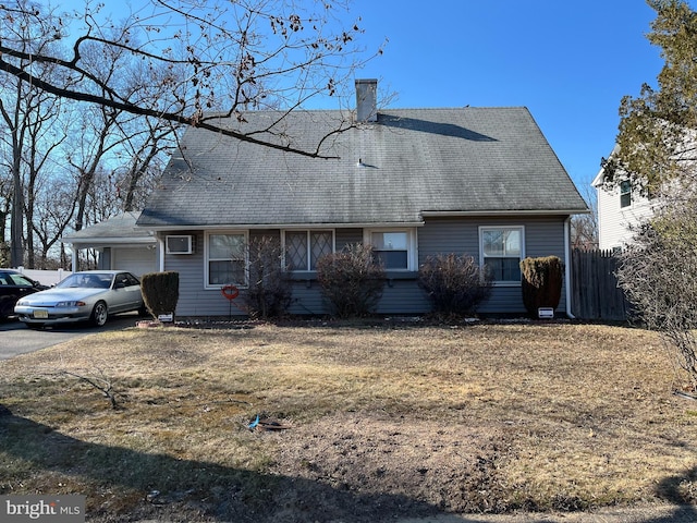 view of front of house with aphalt driveway, a chimney, a shingled roof, an attached garage, and fence