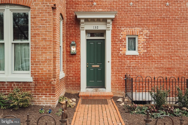 view of exterior entry featuring brick siding