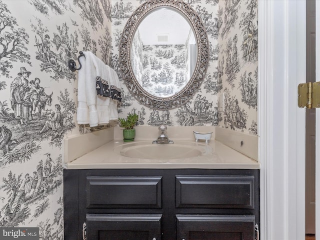 bathroom with wallpapered walls and vanity