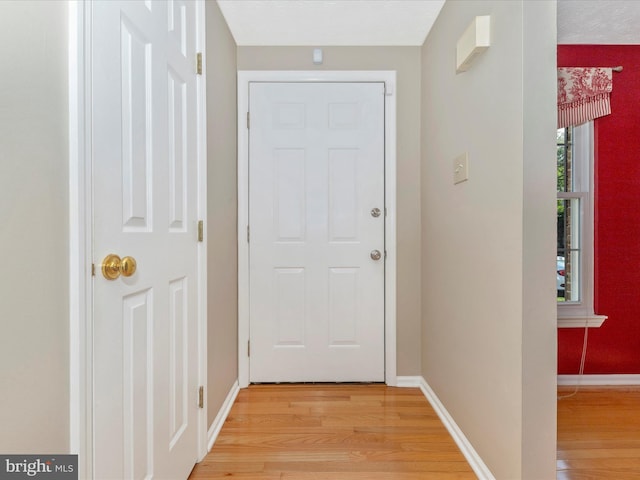 doorway to outside with baseboards and light wood finished floors