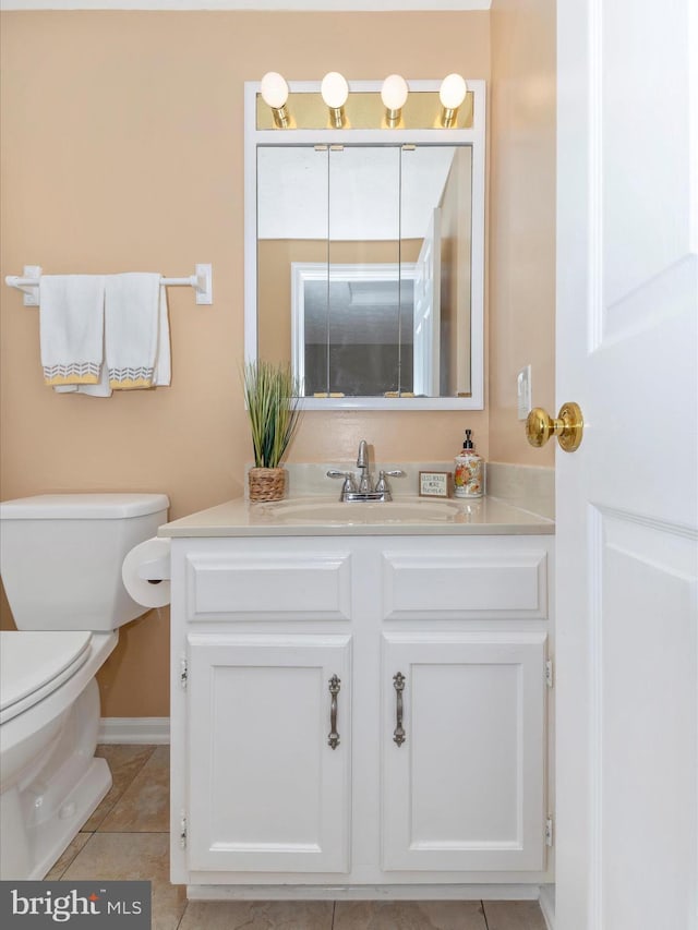 bathroom with toilet, tile patterned flooring, baseboards, and vanity