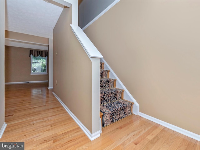 stairway with baseboards and wood finished floors