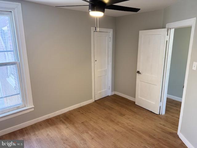 unfurnished bedroom featuring a ceiling fan, light wood-type flooring, and baseboards