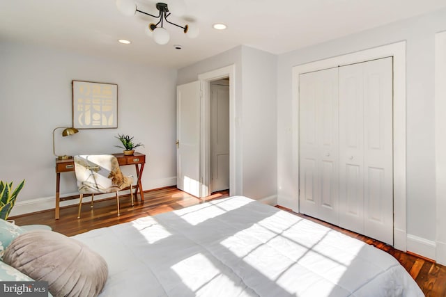 bedroom featuring a closet, recessed lighting, wood finished floors, and baseboards