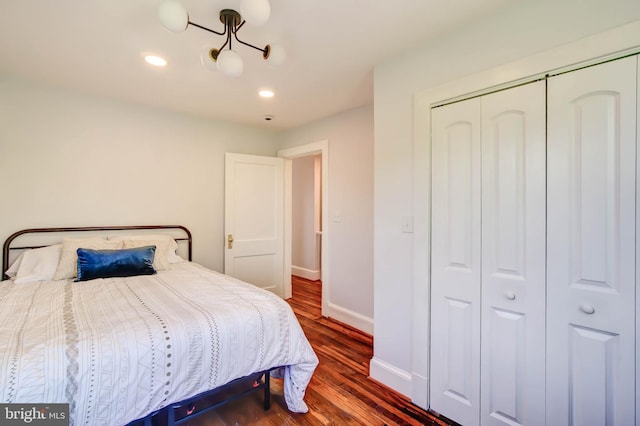 bedroom with a closet, recessed lighting, wood finished floors, and baseboards