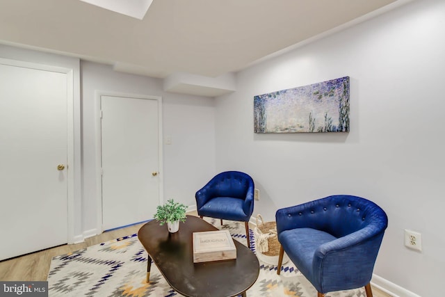 sitting room with baseboards and wood finished floors