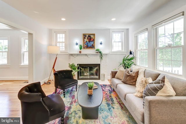 living room featuring recessed lighting, a fireplace, baseboards, and wood finished floors