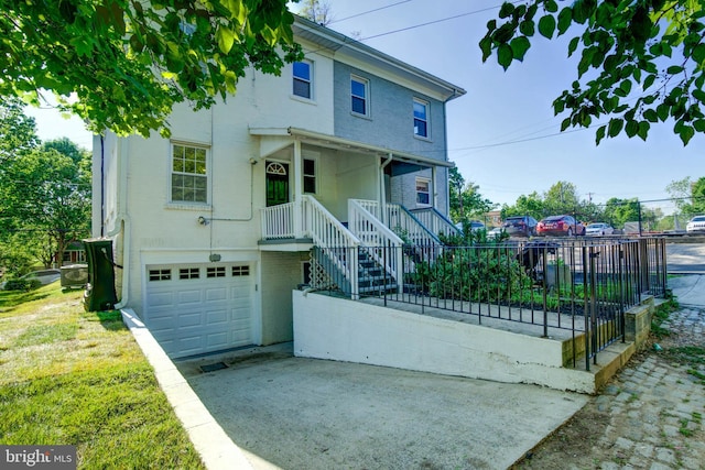 view of front of house featuring driveway, a garage, fence, and brick siding