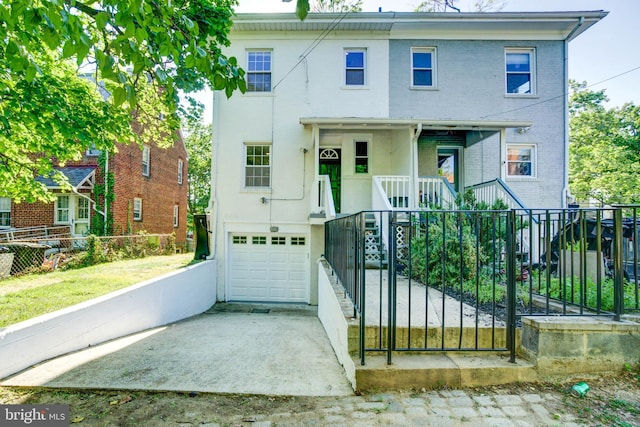 view of front facade with a garage, brick siding, a fenced front yard, and a porch