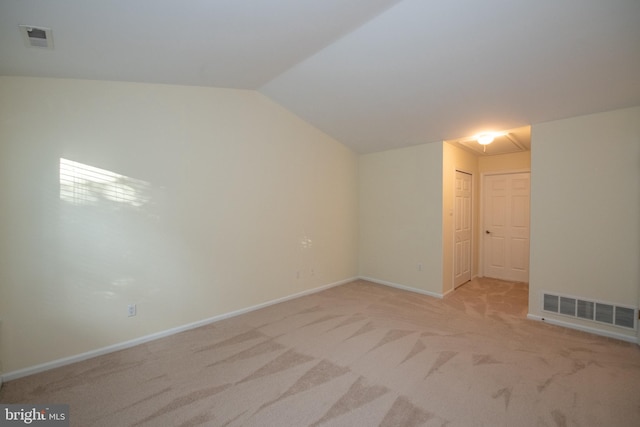 bonus room with lofted ceiling, baseboards, visible vents, and light colored carpet