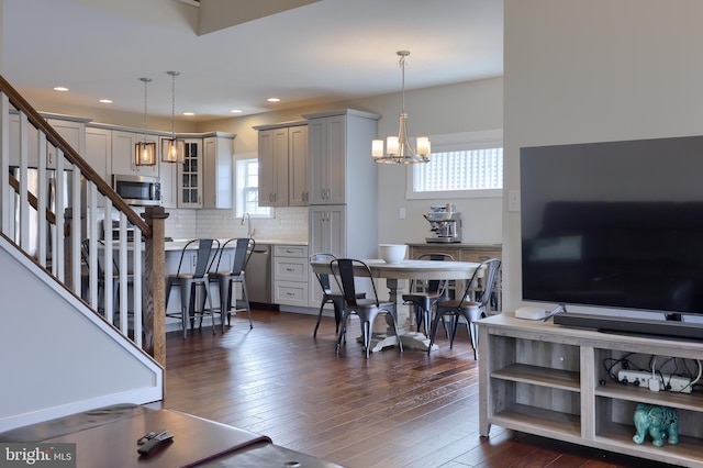 living area featuring plenty of natural light, stairs, and dark wood-type flooring