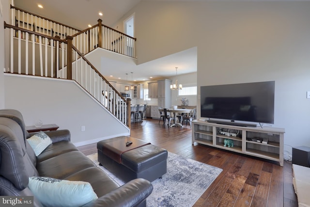 living area with a notable chandelier, recessed lighting, stairway, wood-type flooring, and a towering ceiling