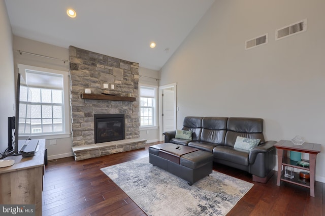 living room with high vaulted ceiling, visible vents, dark wood-type flooring, and a fireplace