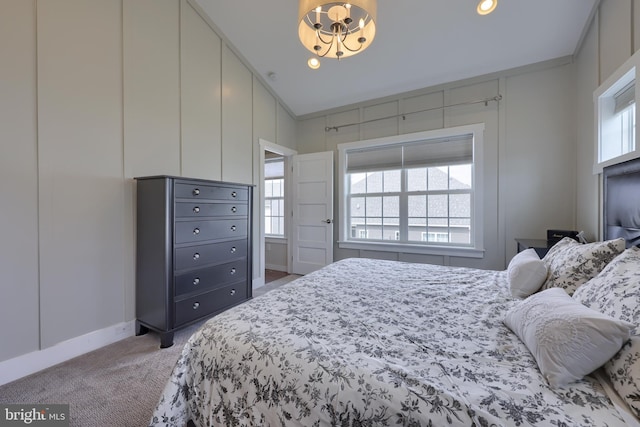 bedroom featuring recessed lighting, light carpet, a notable chandelier, and a decorative wall