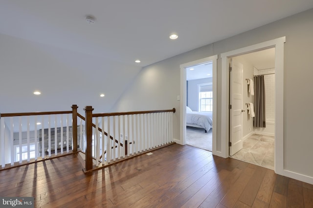 hallway featuring recessed lighting, baseboards, and wood-type flooring