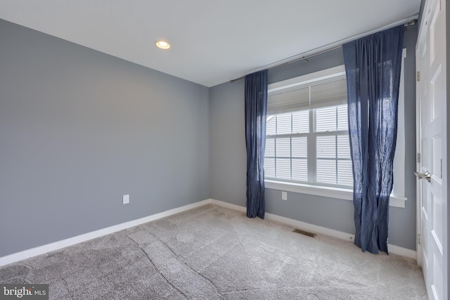 carpeted empty room featuring recessed lighting, visible vents, and baseboards