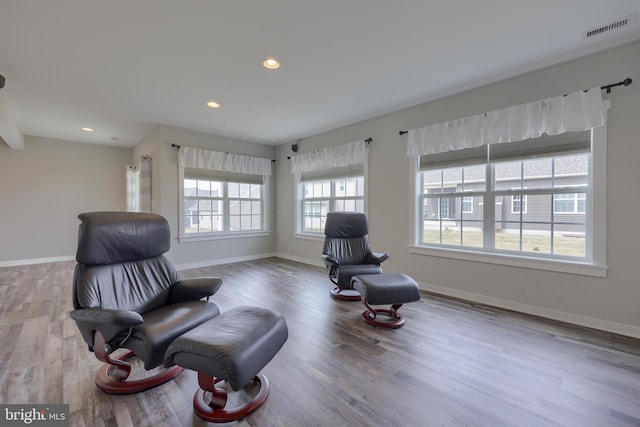 sitting room with visible vents, baseboards, and wood finished floors