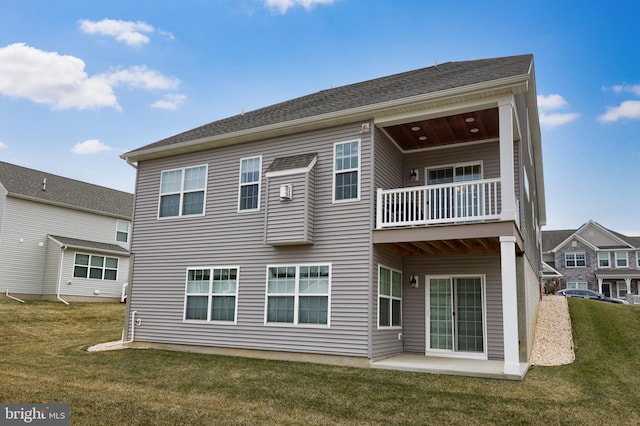 rear view of house with a patio area, a balcony, and a yard