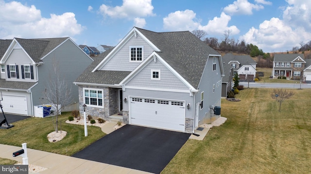 view of front facade featuring a front lawn, driveway, stone siding, roof with shingles, and a garage