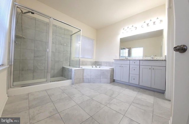 bathroom with a garden tub, a sink, a shower stall, tile patterned floors, and double vanity