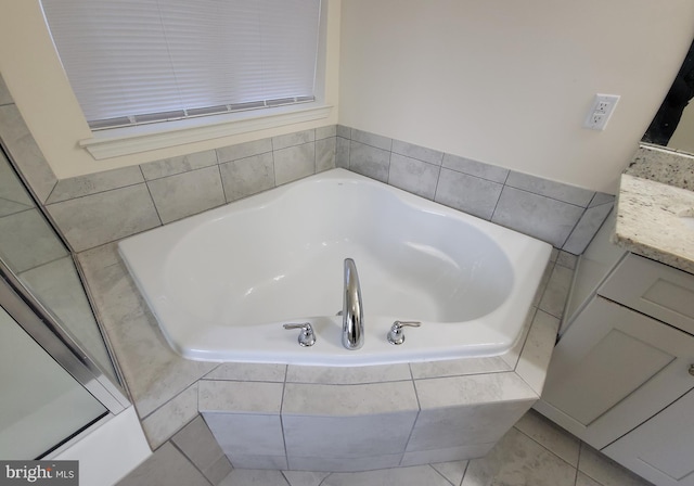 full bathroom with tile patterned flooring, a bath, and vanity