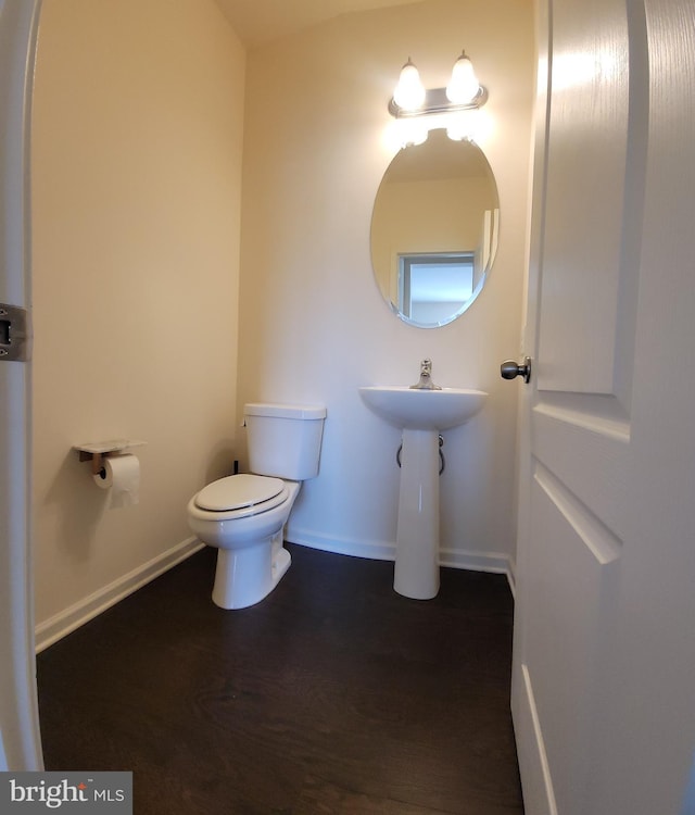 bathroom featuring baseboards, toilet, and wood finished floors