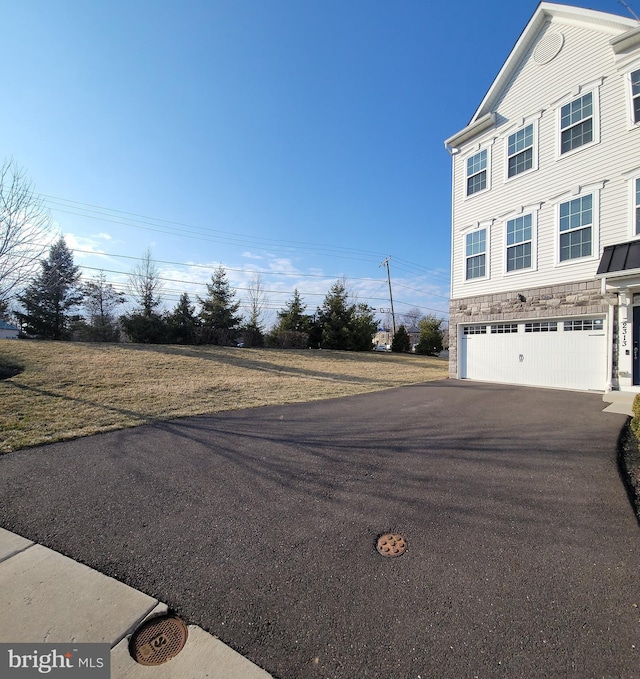 exterior space with a garage and aphalt driveway