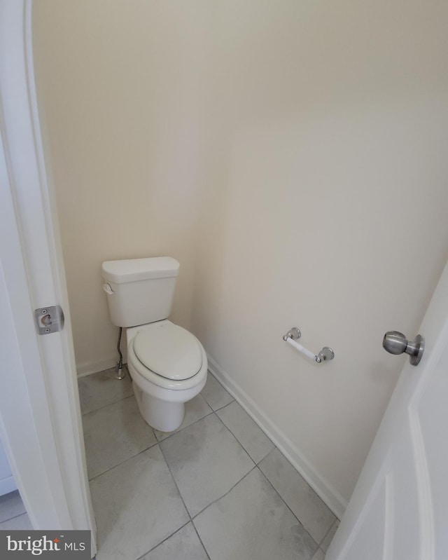 bathroom featuring toilet, tile patterned flooring, and baseboards