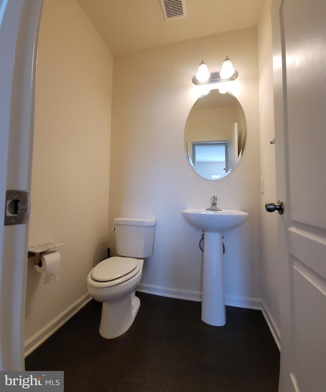 bathroom with toilet, baseboards, and visible vents