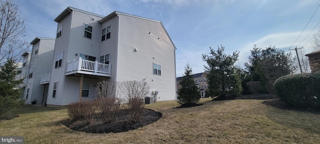 view of home's exterior with cooling unit and a lawn