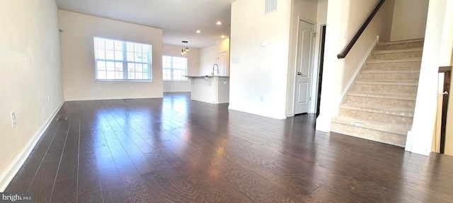 unfurnished living room featuring recessed lighting, dark wood-style flooring, visible vents, and stairway