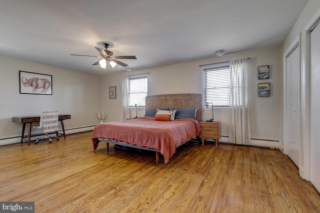 bedroom featuring light wood-style floors, a baseboard radiator, and a ceiling fan