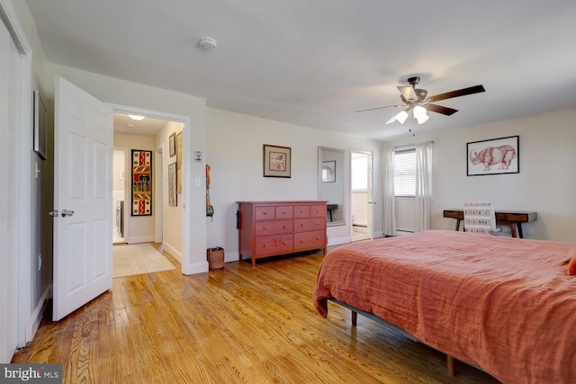 bedroom with ceiling fan, light wood-style flooring, and baseboards