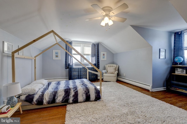 bedroom with lofted ceiling, a baseboard heating unit, and wood finished floors