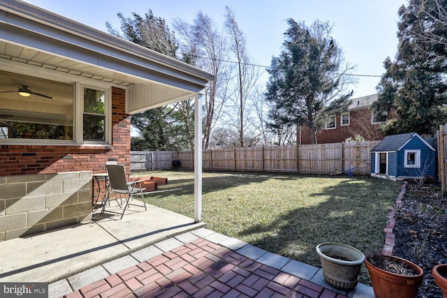 view of yard with an outbuilding, a storage unit, a patio area, and a fenced backyard