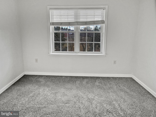 unfurnished room with carpet flooring and baseboards