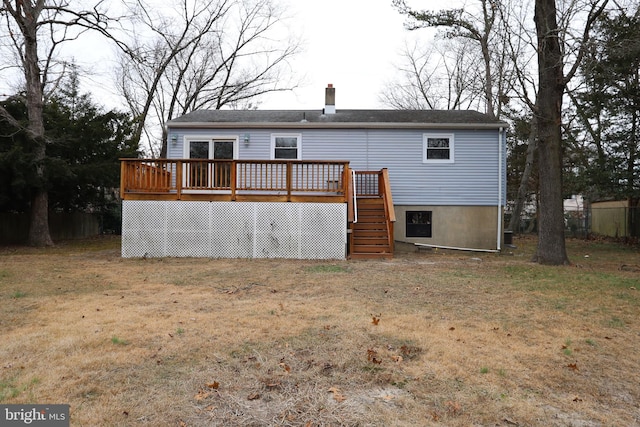 back of house with a deck, a yard, and a chimney