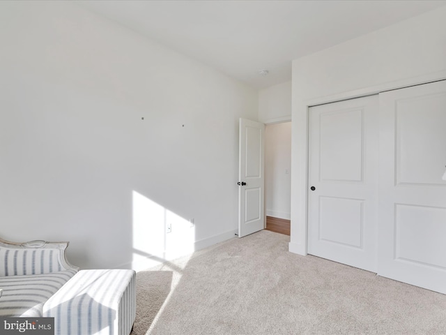 bedroom with carpet flooring, baseboards, and a closet