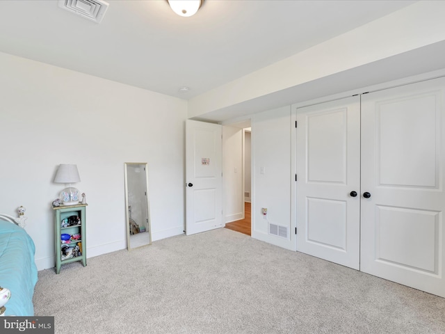 unfurnished bedroom with visible vents, baseboards, carpet, and a closet