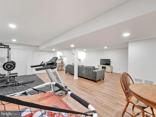 workout area with light wood finished floors, visible vents, and recessed lighting