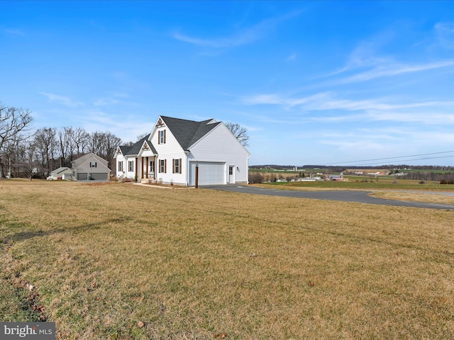 view of front of home featuring aphalt driveway, a garage, and a front yard