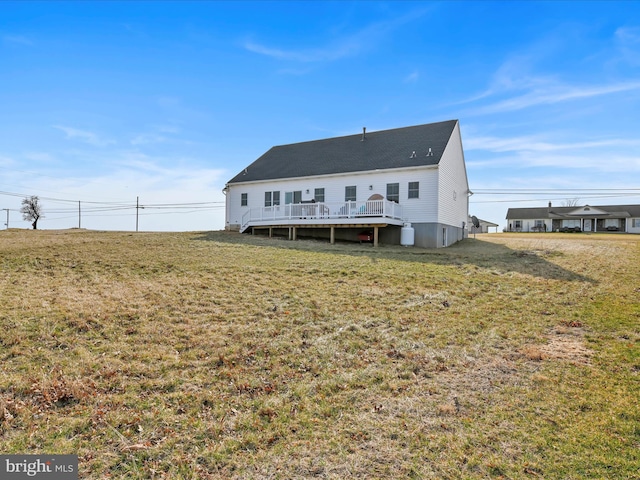 rear view of house featuring a yard and a wooden deck