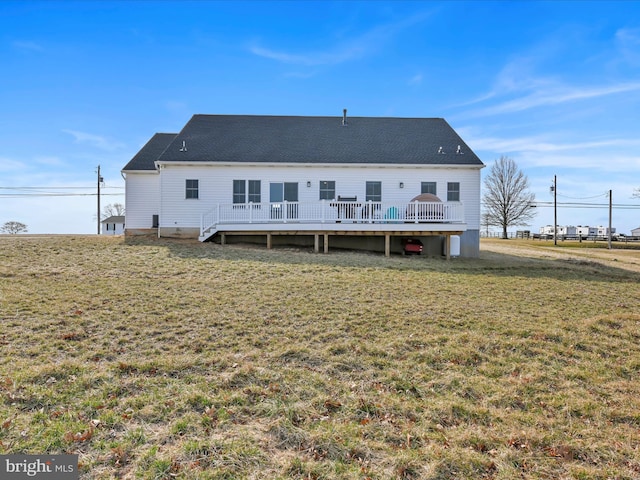 rear view of house featuring a wooden deck and a lawn