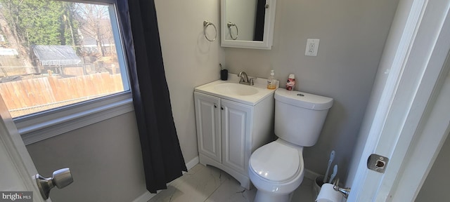 bathroom featuring toilet, marble finish floor, baseboards, and vanity