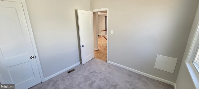 unfurnished bedroom with baseboards, visible vents, and carpet flooring