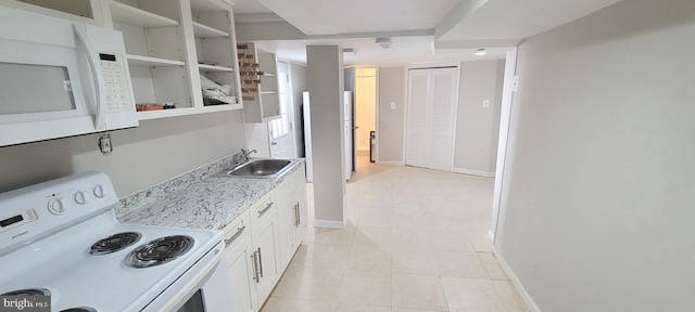 kitchen with white appliances, baseboards, white cabinets, light countertops, and a sink