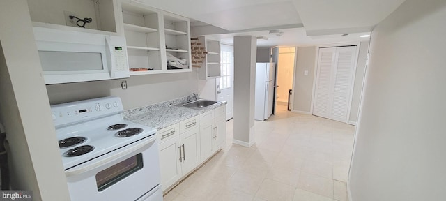 kitchen featuring light countertops, white appliances, a sink, and white cabinetry