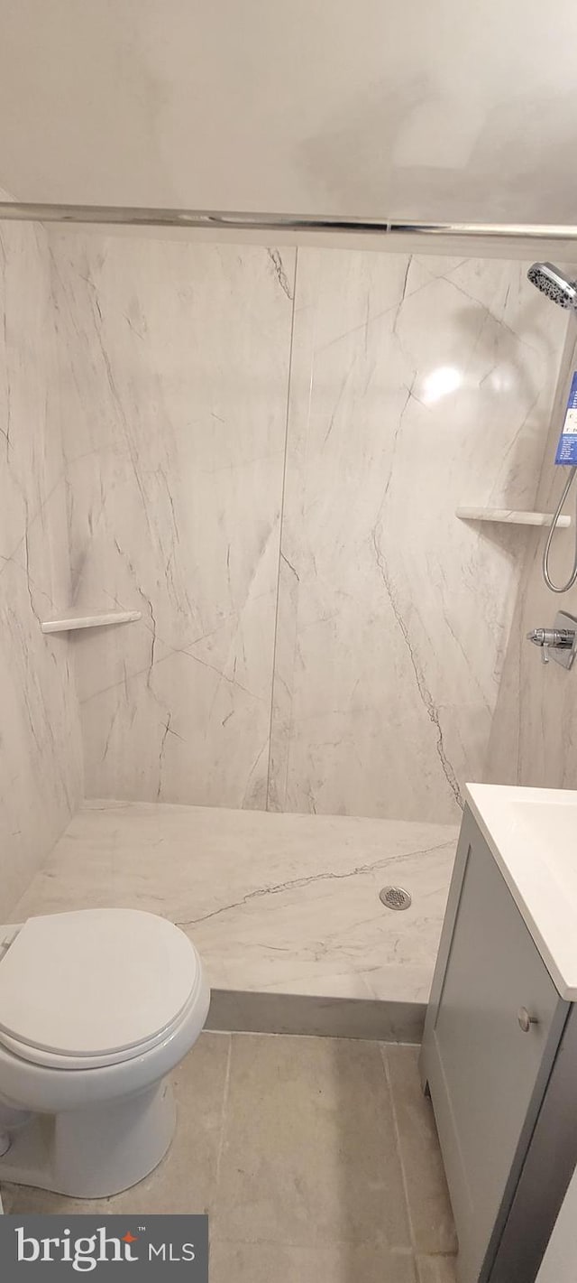 bathroom with a stall shower, vanity, and toilet