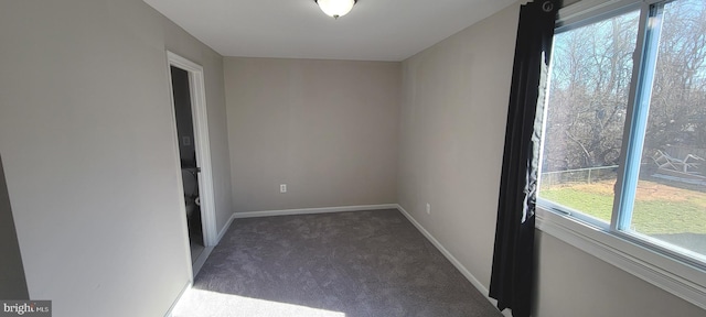 carpeted spare room featuring baseboards