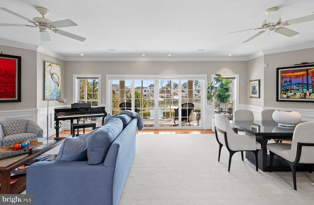 living room featuring plenty of natural light, crown molding, and a wainscoted wall